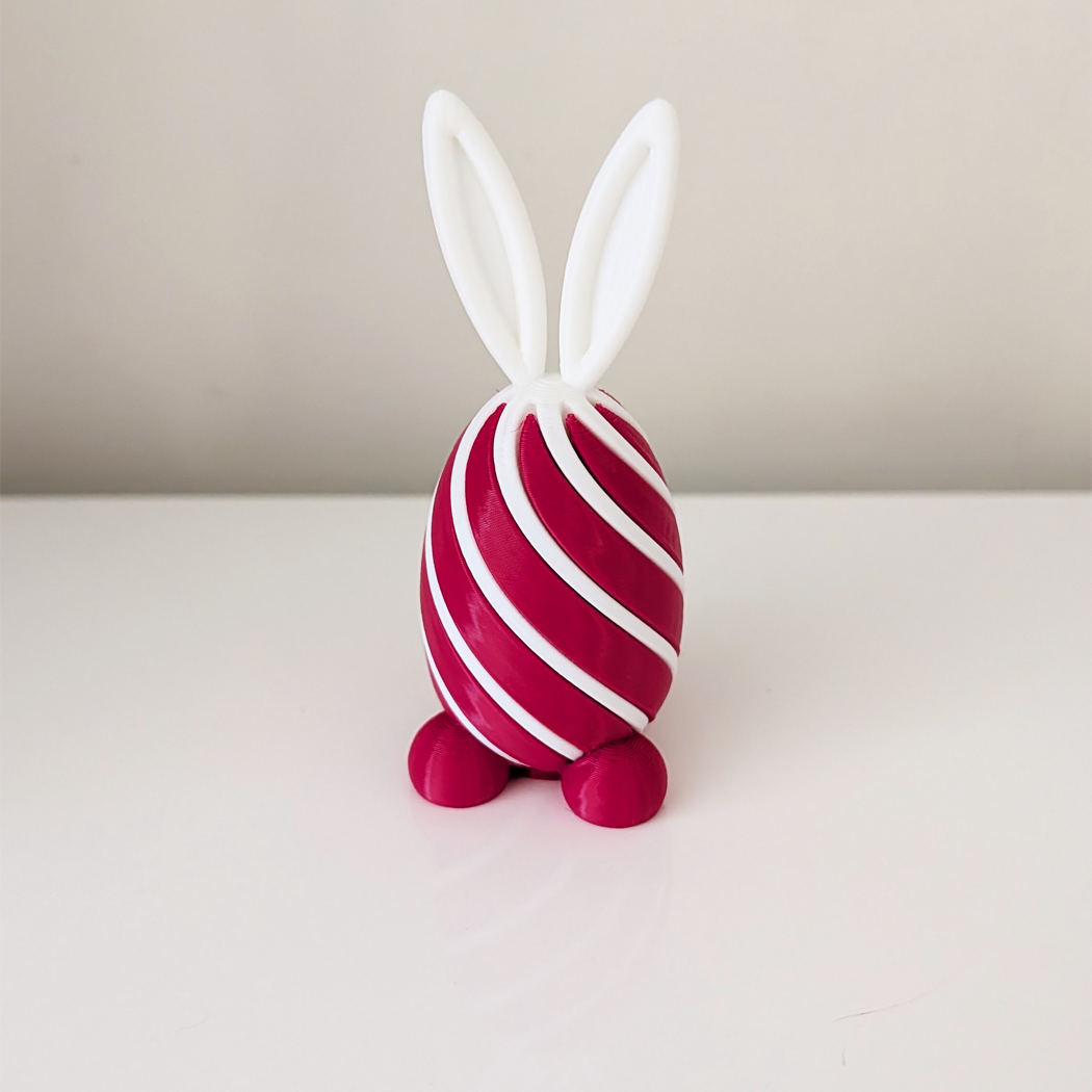 Pink and white striped toy rabbit on a light background