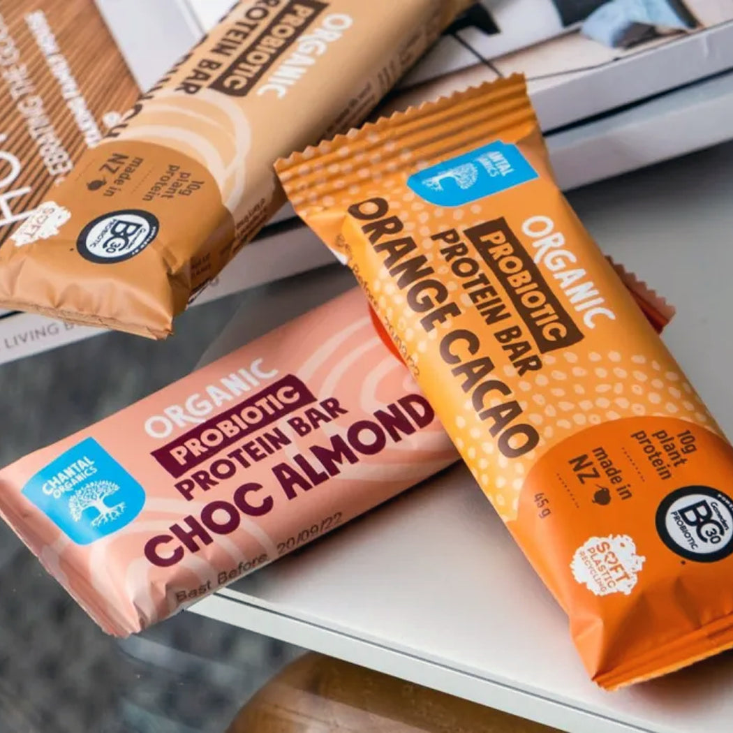Three organic probiotic protein bars on a surface