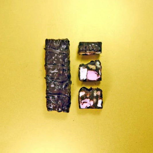 Dark chocolate truffles with visible toppings on a yellow background