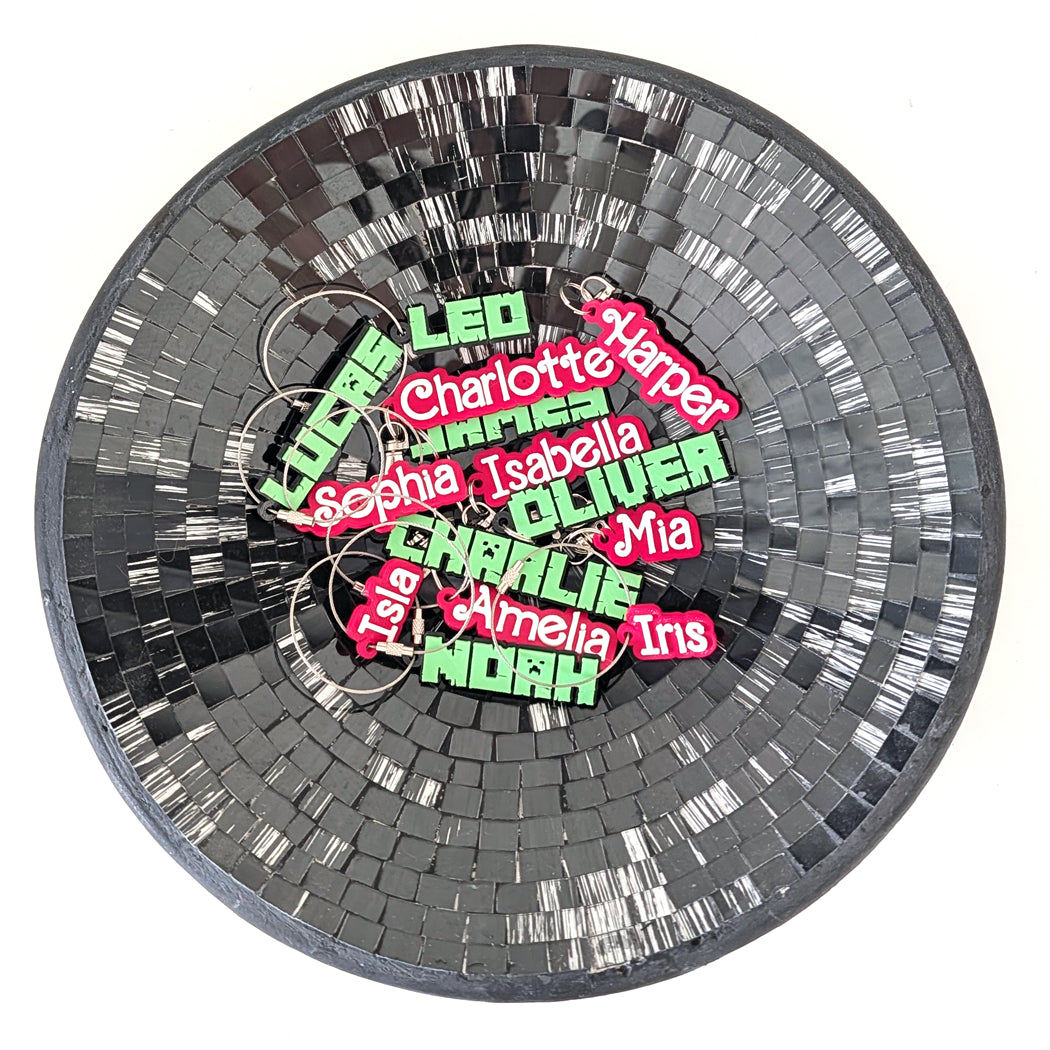 Round mosaic coaster with colorful name tags on a white background