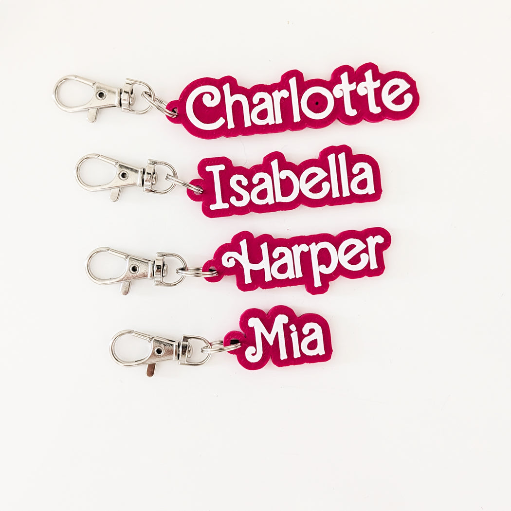 Four keychains with personalized names 'Charlotte', 'Isabella', 'Harper', and 'Mia' on a white background.