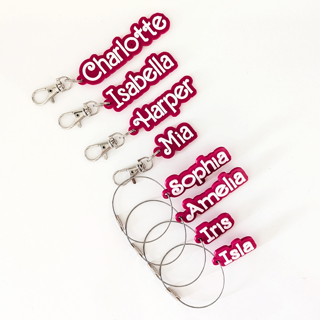 Set of name tags with pink names on a white background