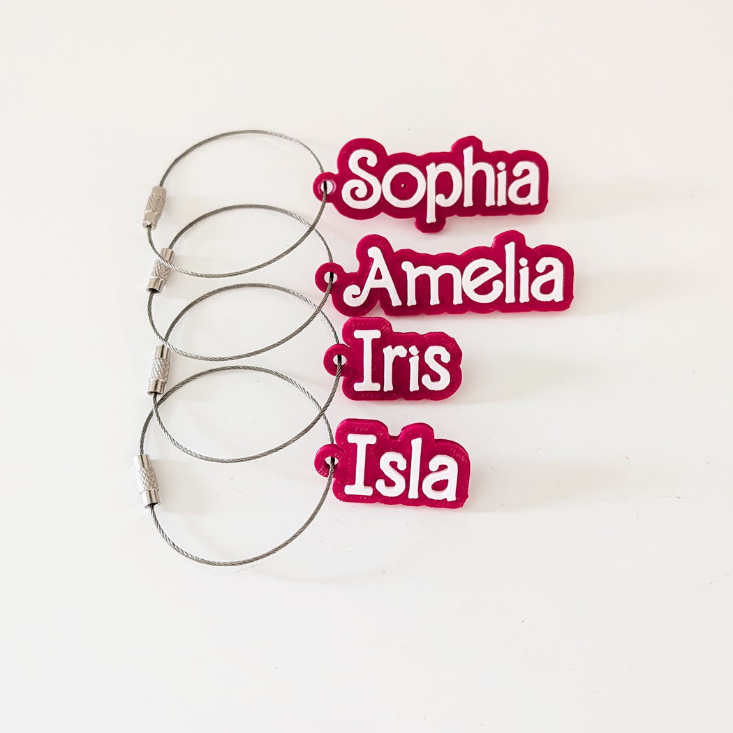 Set of hair ties with personalized names in red text on a white background
