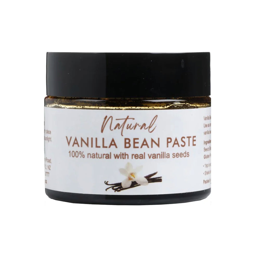 Jar of natural vanilla bean paste with a black lid on a white background