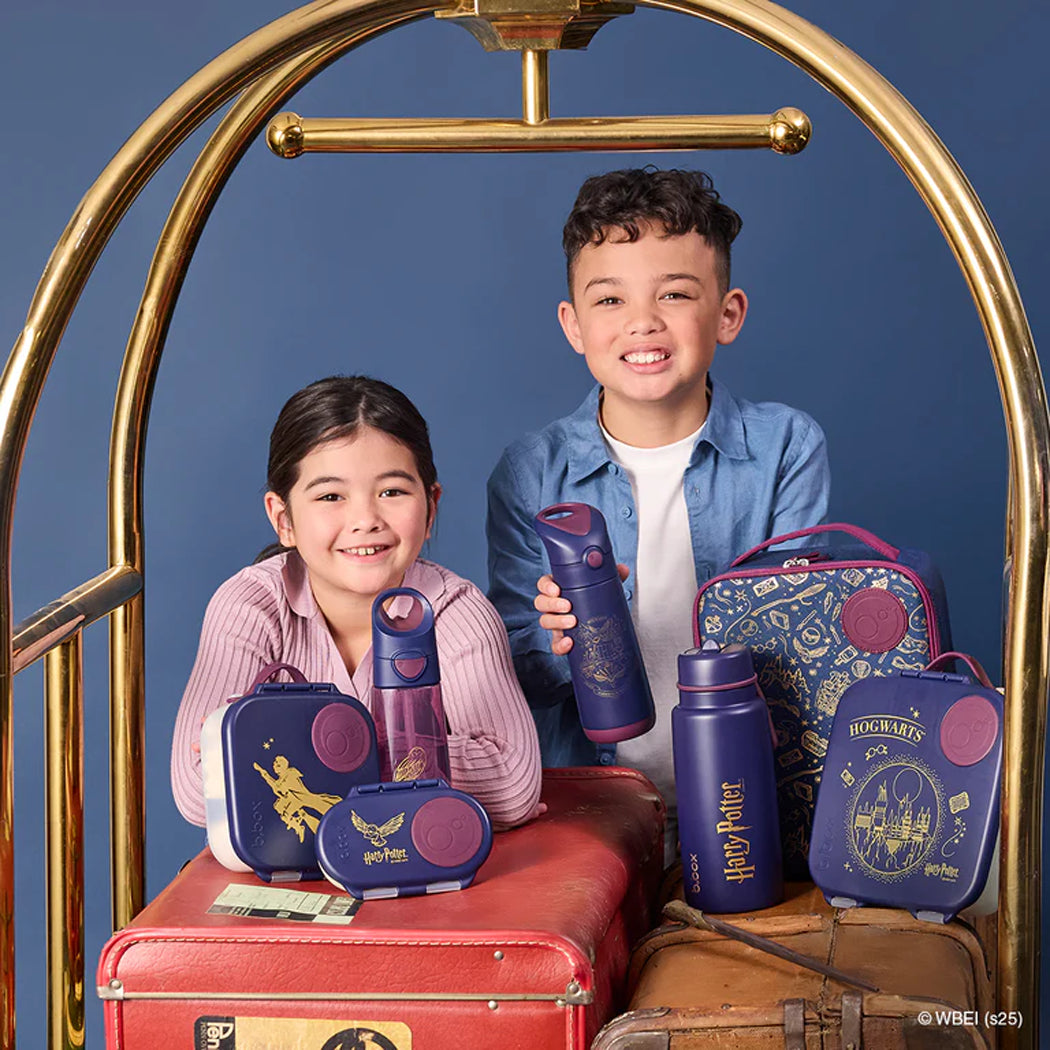 Two children with Harry Potter-themed travel sets against a blue background