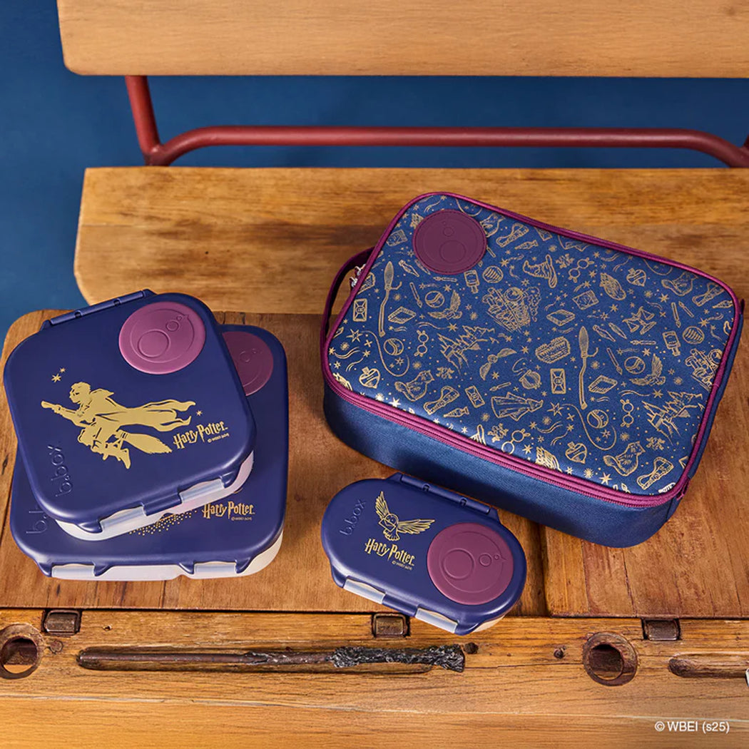 Set of Harry Potter-themed lunch boxes on a wooden surface with a blue background.