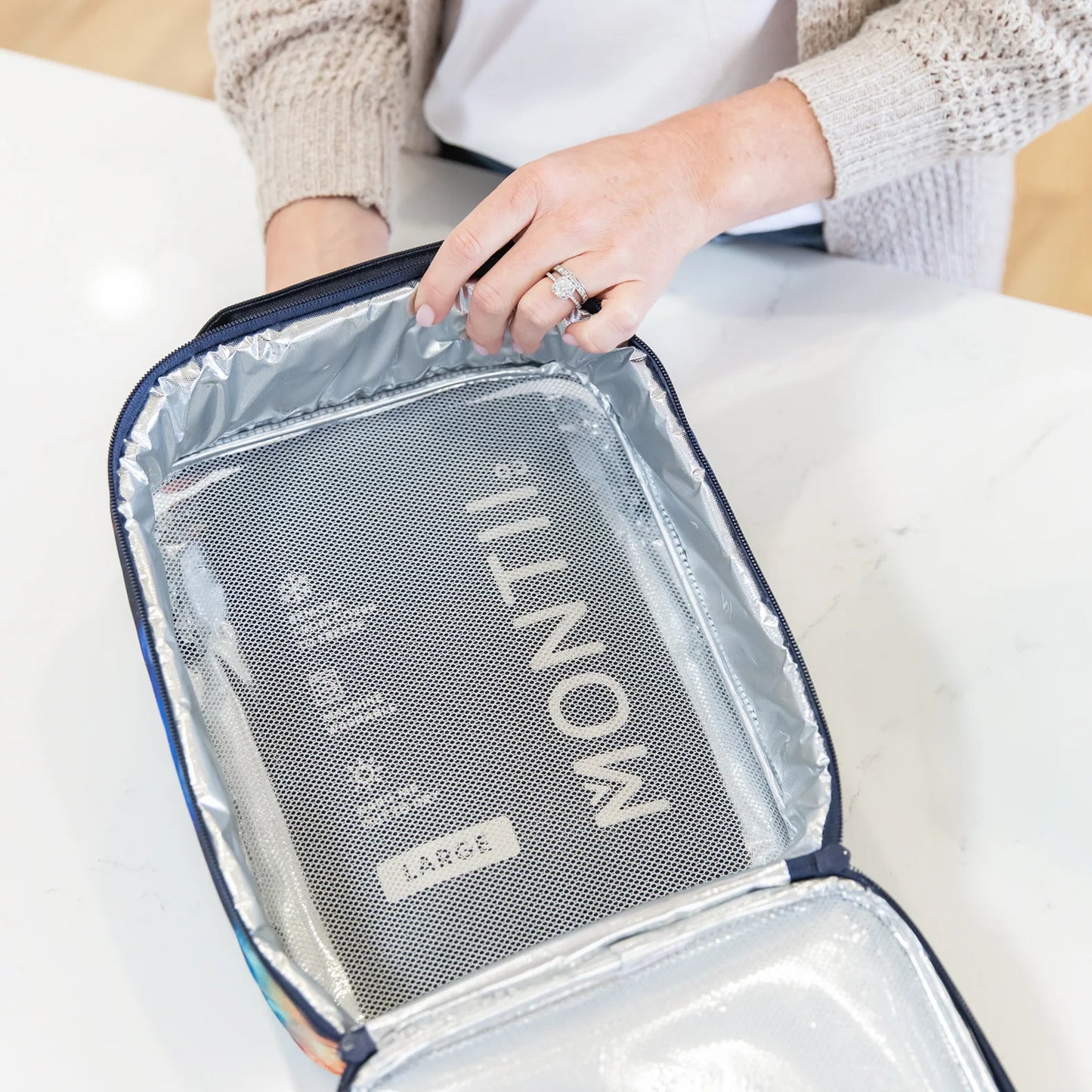 Person holding a clear travel packing cube with 'Montii' branding.