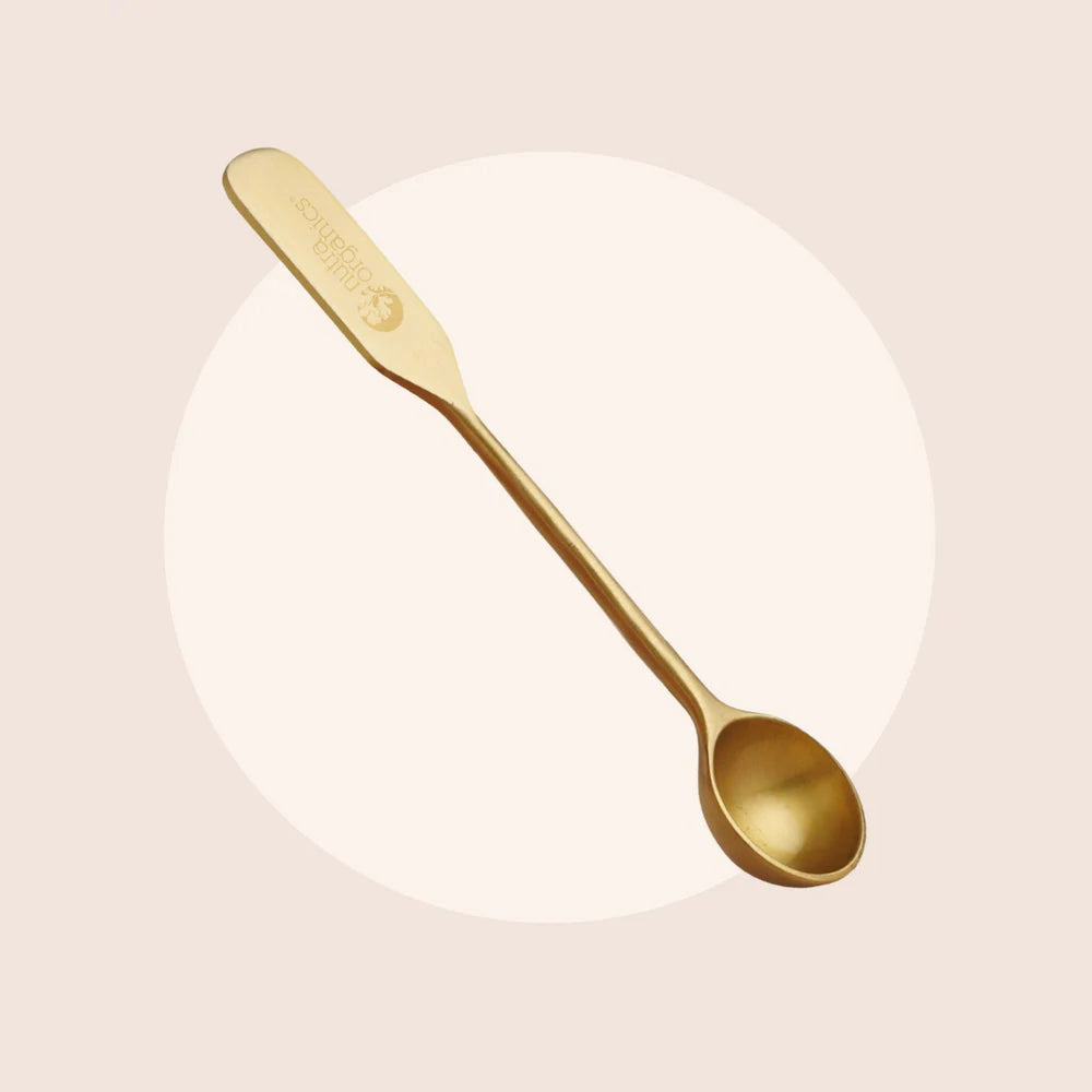 Gold spoon on a light beige background