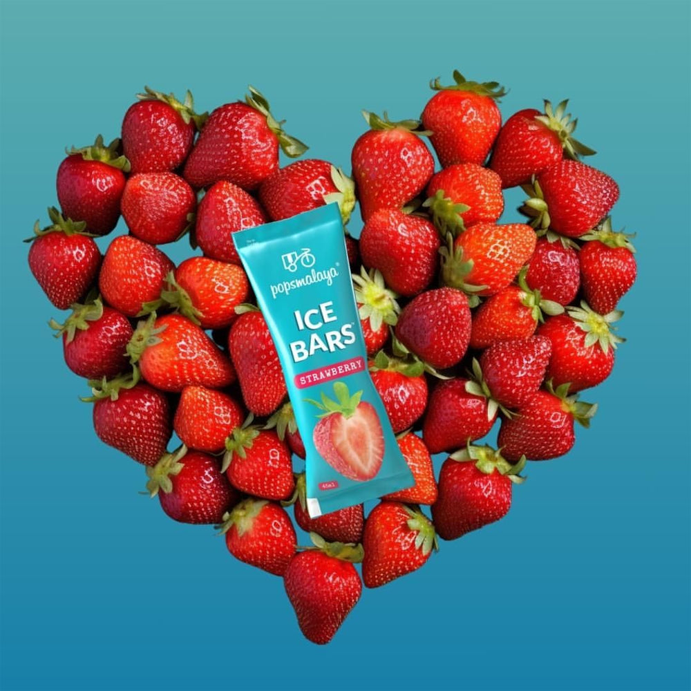 Strawberries arranged in a heart shape with a packet of strawberry ice bars on a blue background