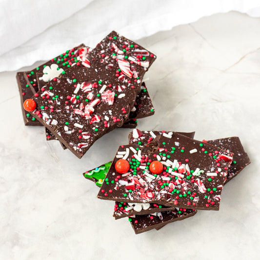 Chocolate bark with festive sprinkles on a white marble surface
