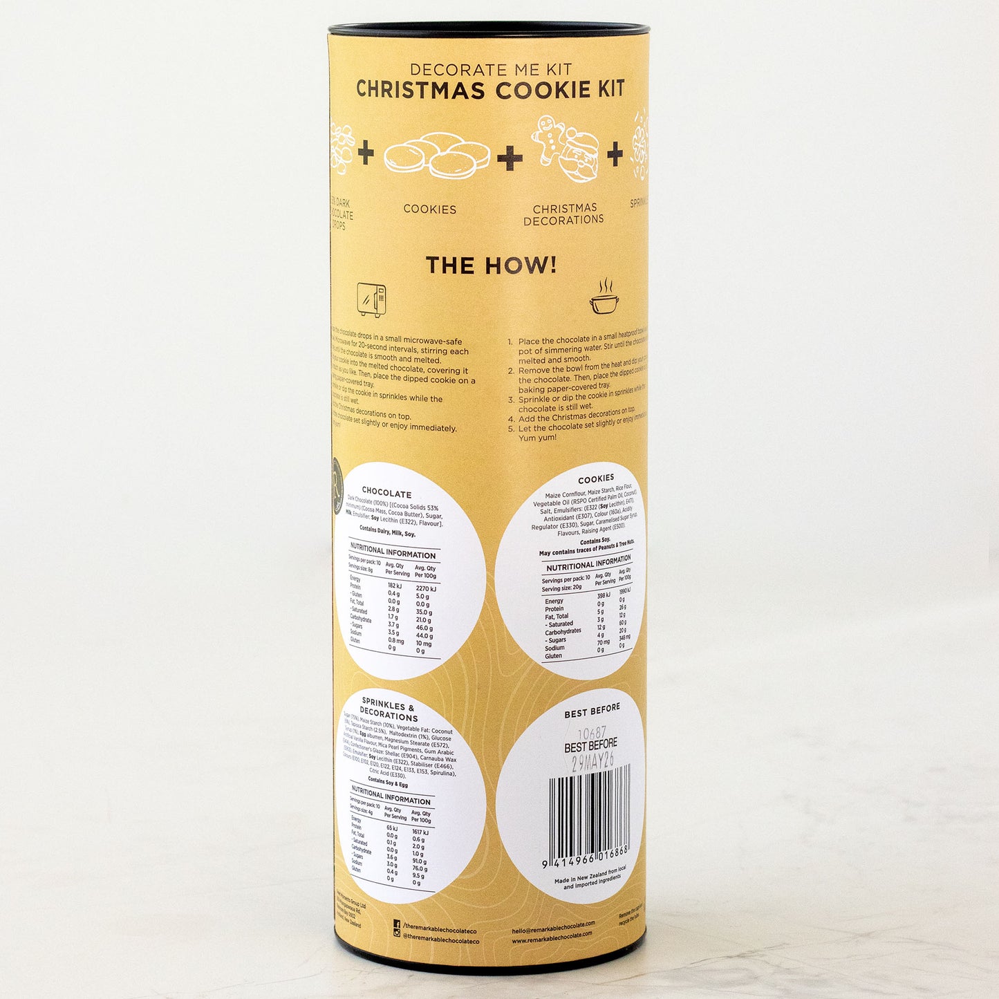 Yellow cylindrical packaging for a Christmas cookie kit on a white background