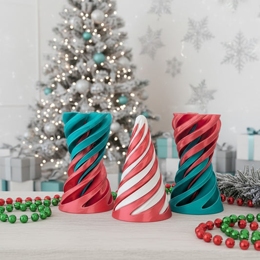 Colorful spiral candle holders on a table with a Christmas tree in the background