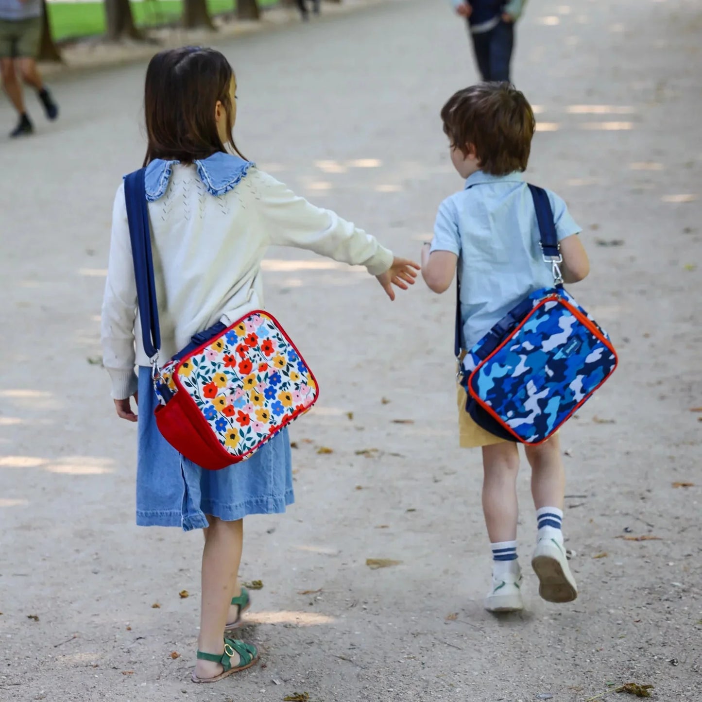 Two children walking outdoors with colorful backpacks