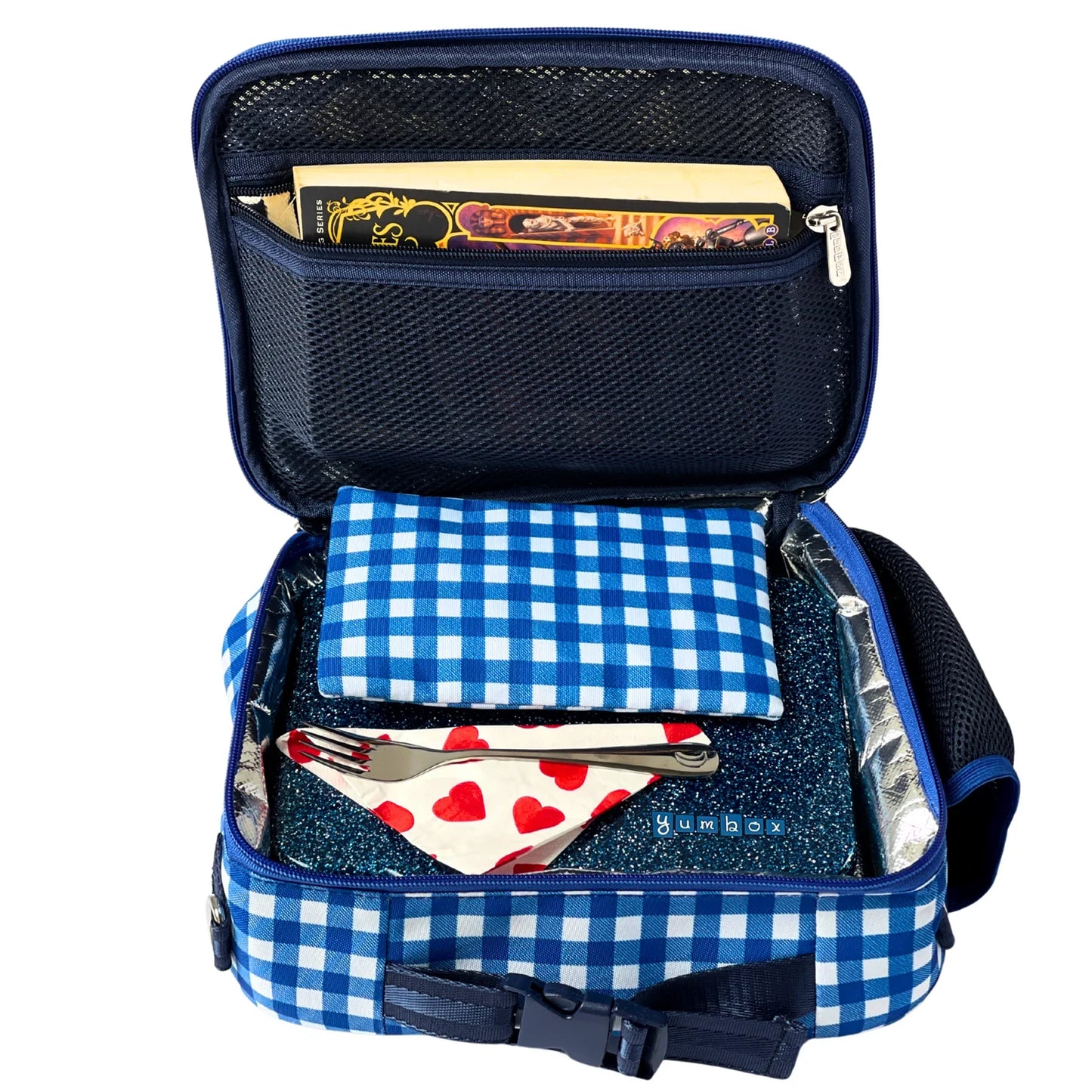 Open blue checkered lunch bag with contents including a fork, heart-patterned napkin, and books.