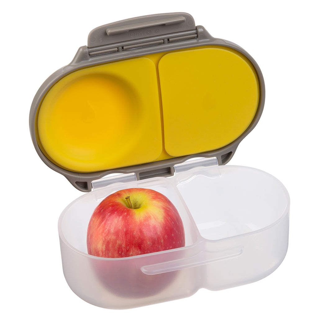 Portable food container with a yellow lid and an apple inside on a white background