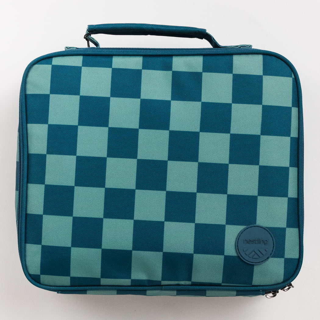 A square soft-sided bag with a teal and mint green checkerboard pattern, featuring a top handle and a circular Nestling logo patch on the lower right.