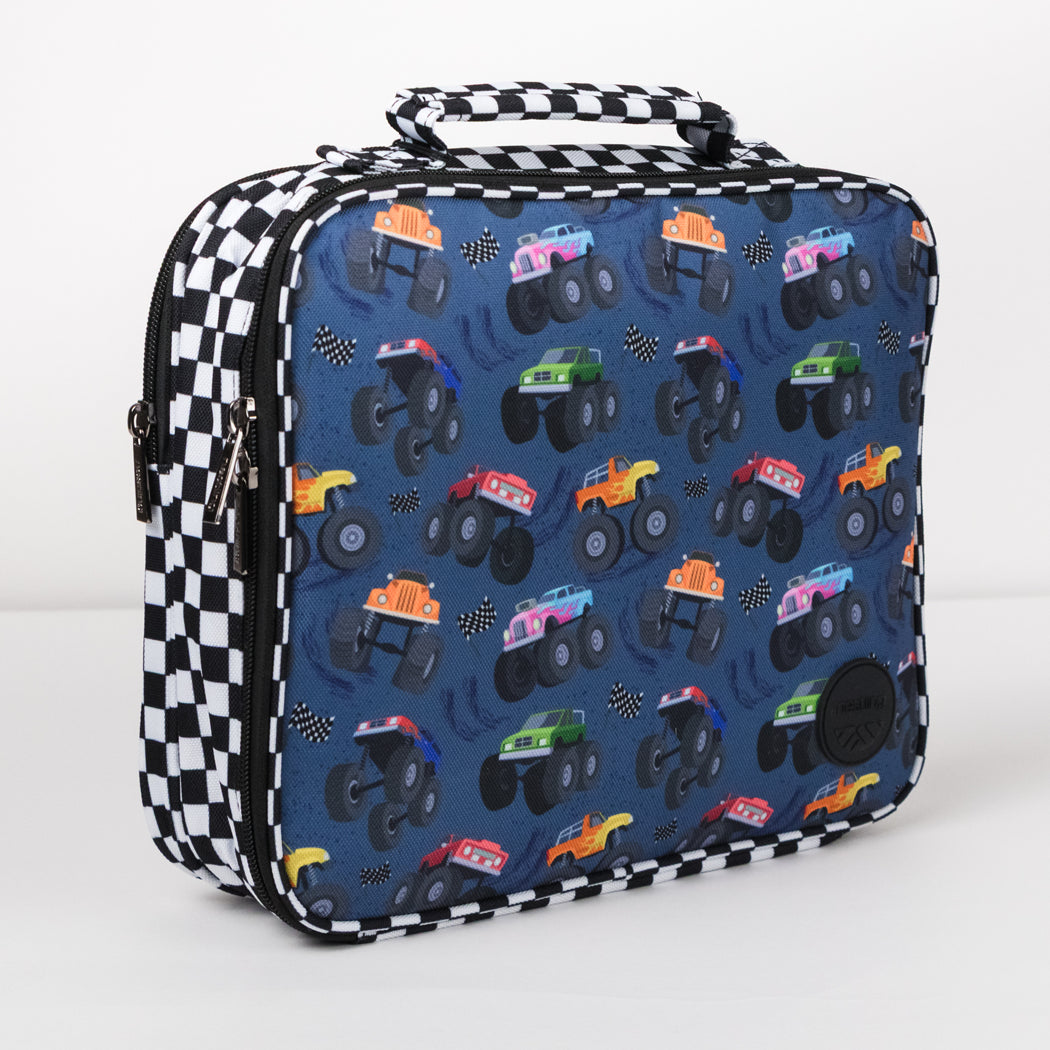 A rectangular lunch bag with a blue background printed with colorful monster trucks, black-and-white checkered trim, and a top handle, photographed on a clean white background.