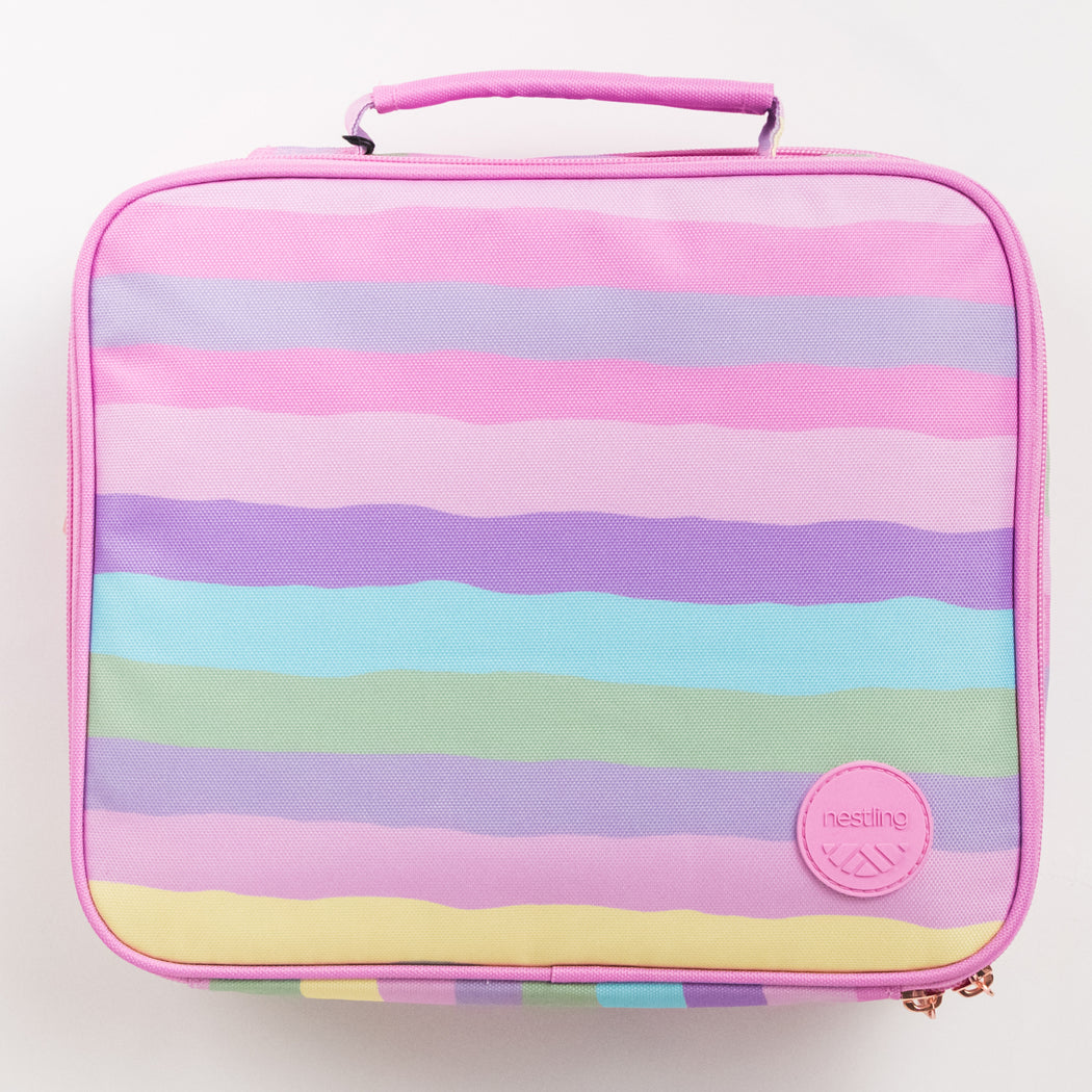 A rectangular lunch bag with a colorful pastel stripe pattern in pink, purple, blue, green, and yellow, featuring a pink top handle and a pink circular Nestling Kala logo patch on the bottom right.