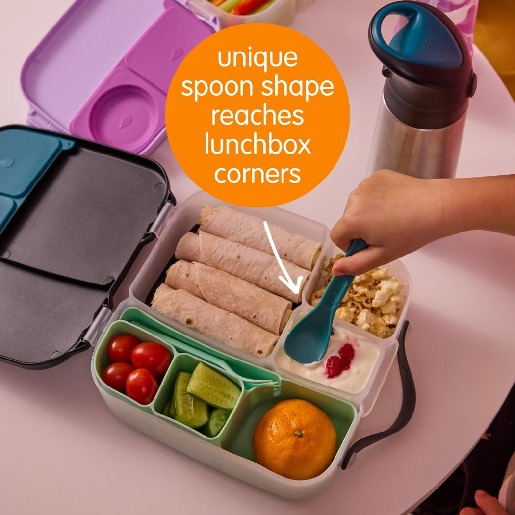 Lunchbox with compartments filled with food, including wraps, fruits, and vegetables, with a unique spoon shape feature highlighted.