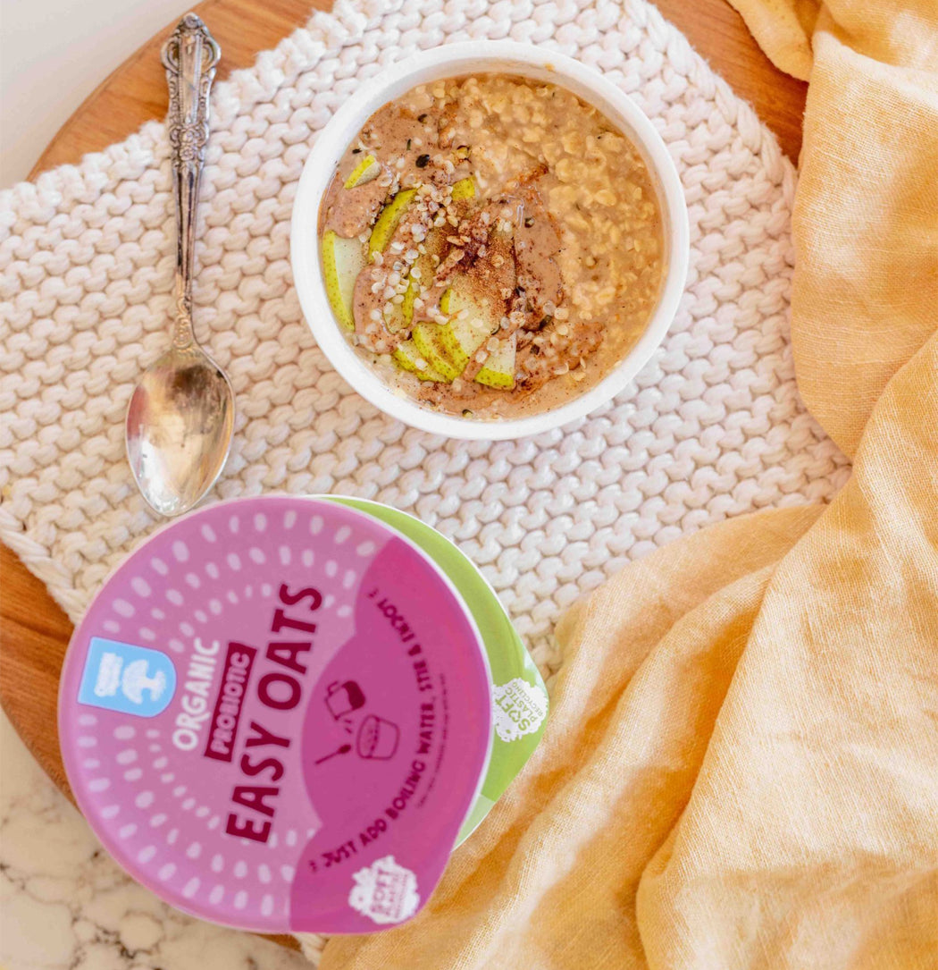 Container of Organic Producos Easy Oats with a bowl of oatmeal on a textured surface.