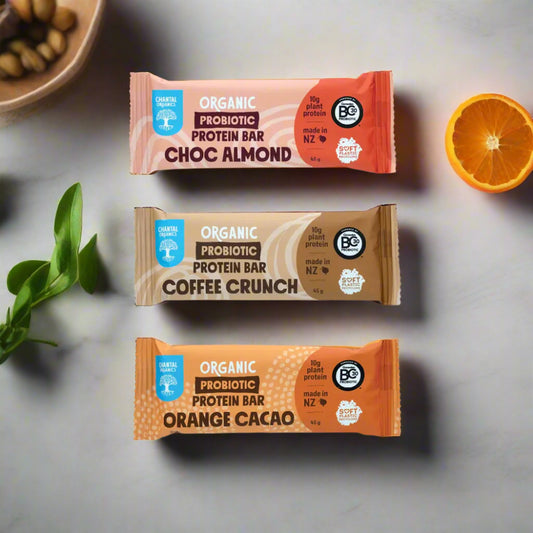 Three organic probiotic protein bars in different flavors on a white background