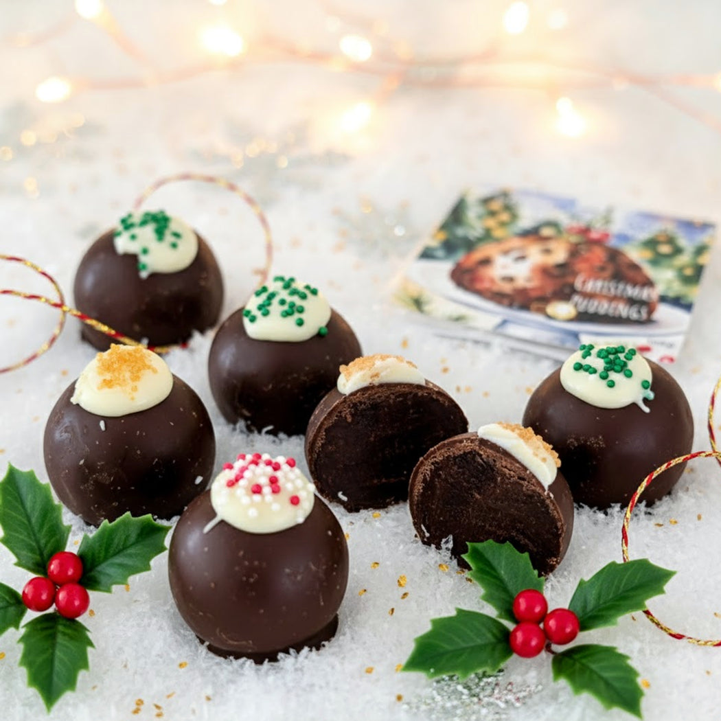 Decorative chocolate truffles with festive toppings on a snowy background with Christmas decorations.