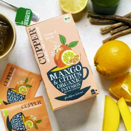 Box of Cupper Mango & Citrus Organic Infusion with lemons and tea leaves on a white surface