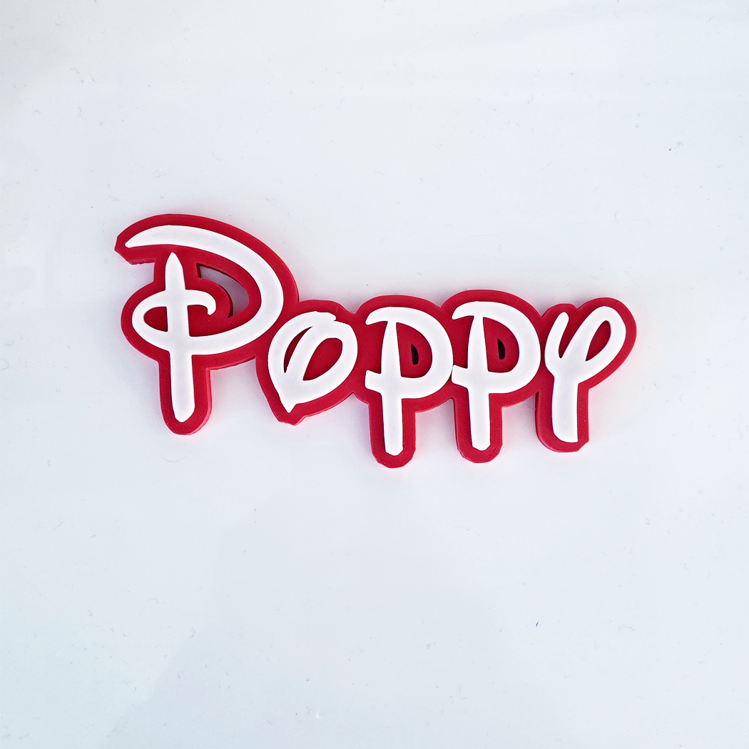 A red and white 3D acrylic word art sign spelling 'Poppy' in a Disney-style cursive font, shown on a plain white background.