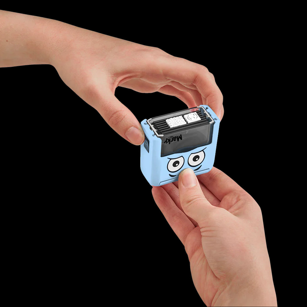 Small blue device with cartoon face held between two hands against a black background