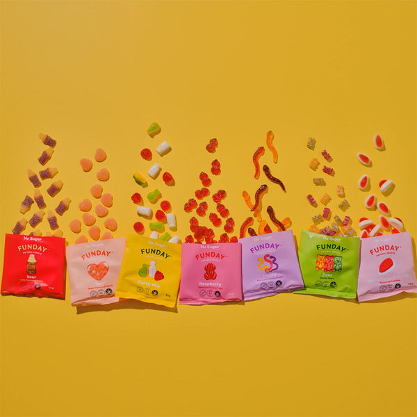 Colorful Funday candy packets on a yellow background with scattered candy pieces.