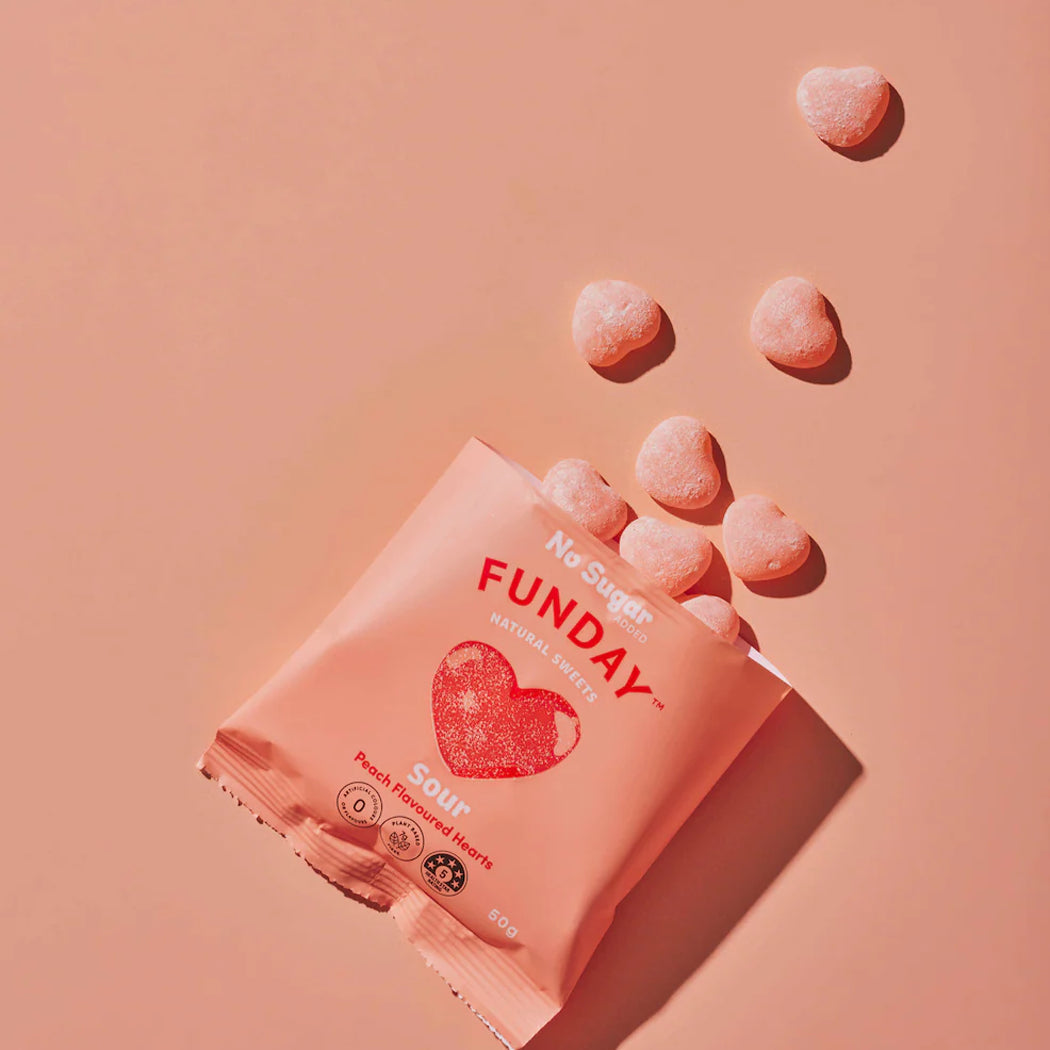 Funday no sugar peach flavored heart-shaped candy on a pink background