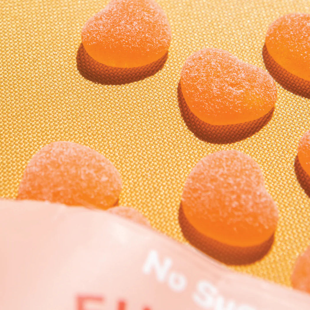 Gummy bears on a textured yellow background with 'No Sugar' text.