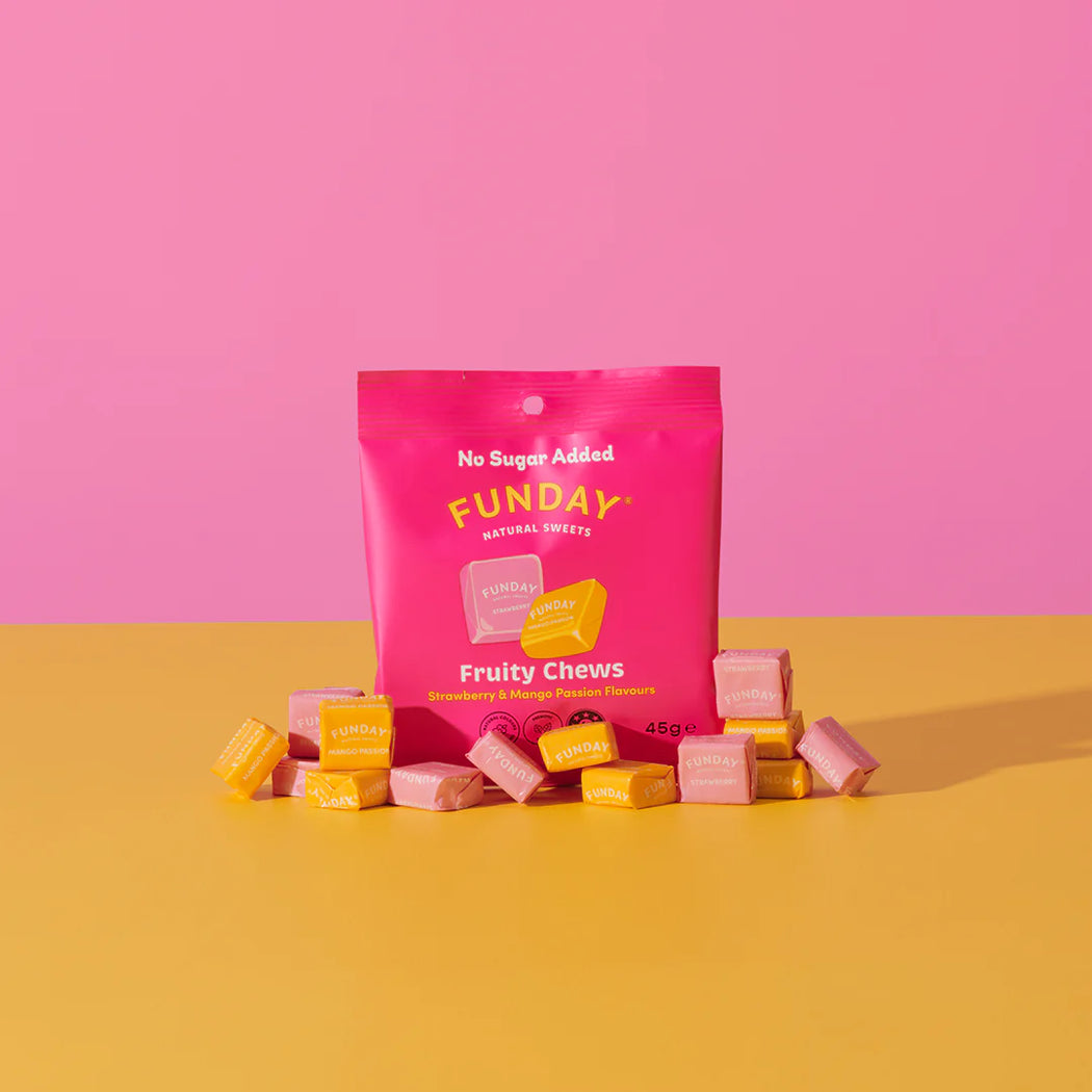Pink bag of Funday Fruity Chews on a yellow surface with a pink background