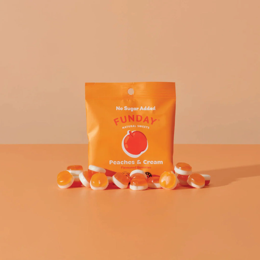 Funday peaches and cream gummy bears with an orange package on a peach background