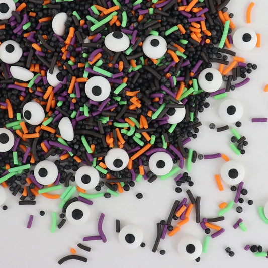 Halloween-themed sprinkles with eyeballs, black, orange, and green on a white background