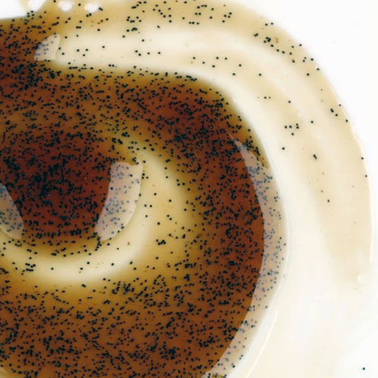 Close-up of a dessert with a swirl pattern and poppy seeds on top.