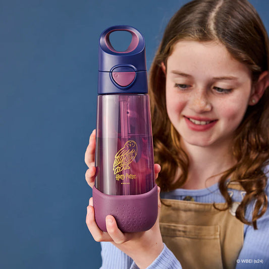Child holding a purple water bottle with a Harry Potter logo against a blue background