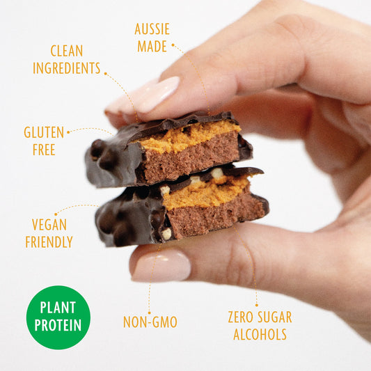 Hand holding a stack of chocolate protein bars with health benefits text overlay on a white background