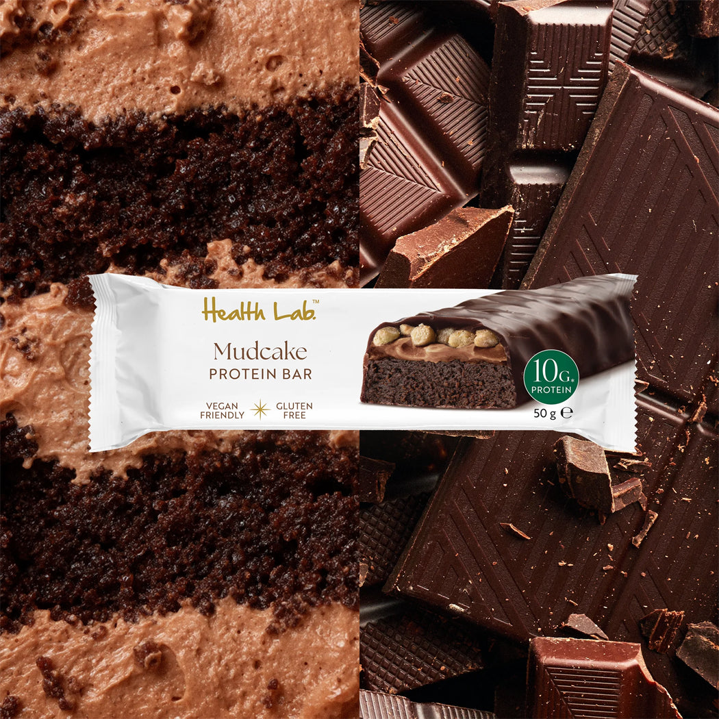 Health Lab Mudcake Protein Bar surrounded by chocolate cake and chocolate pieces