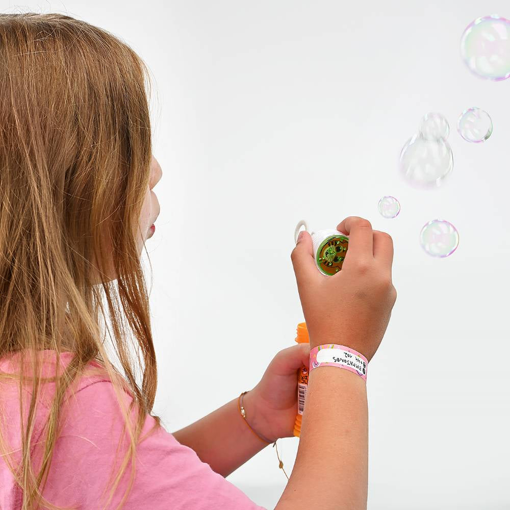 Child blowing bubbles with a bubble wand on a white background