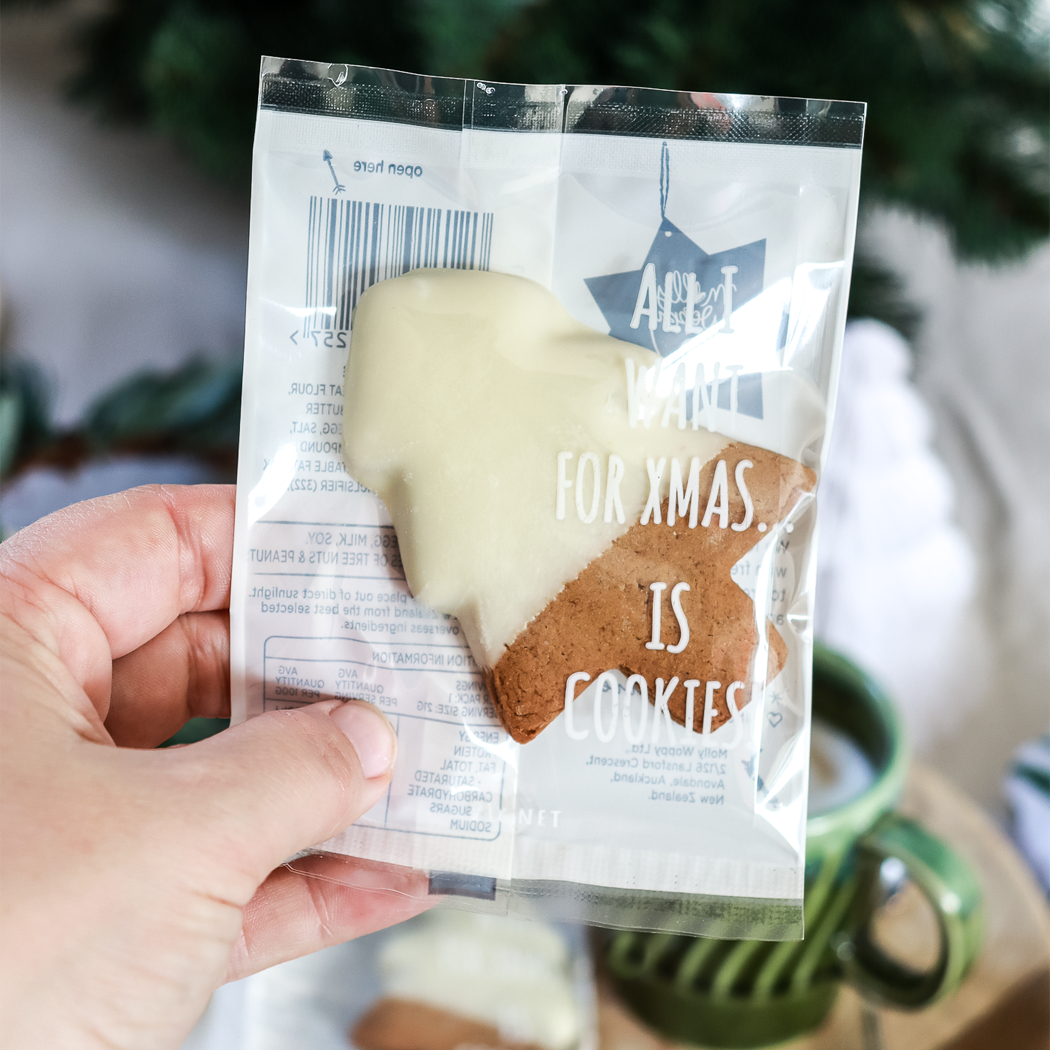Hand holding a package of cookies with a Christmas-themed message.