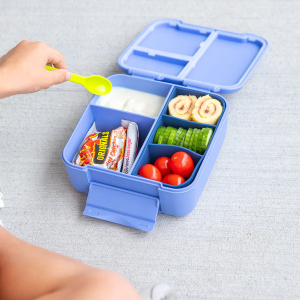 Blue bento box with compartments containing food items on a light gray surface.