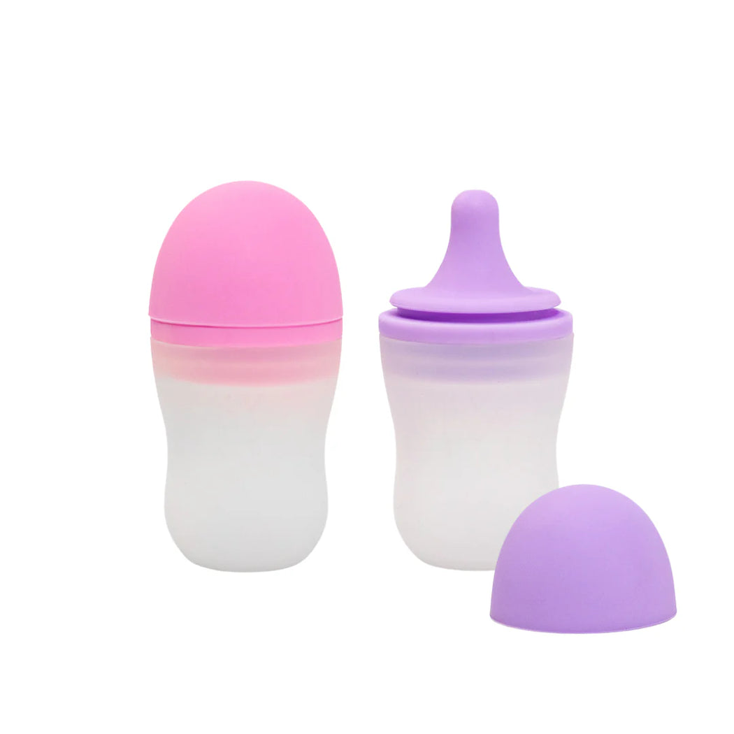 Two gradient-colored baby bottles on a white background