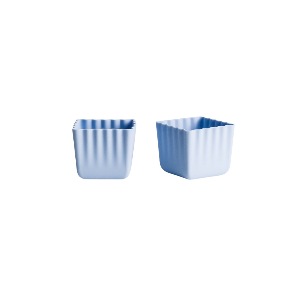 Two blue silicone pots on a white background