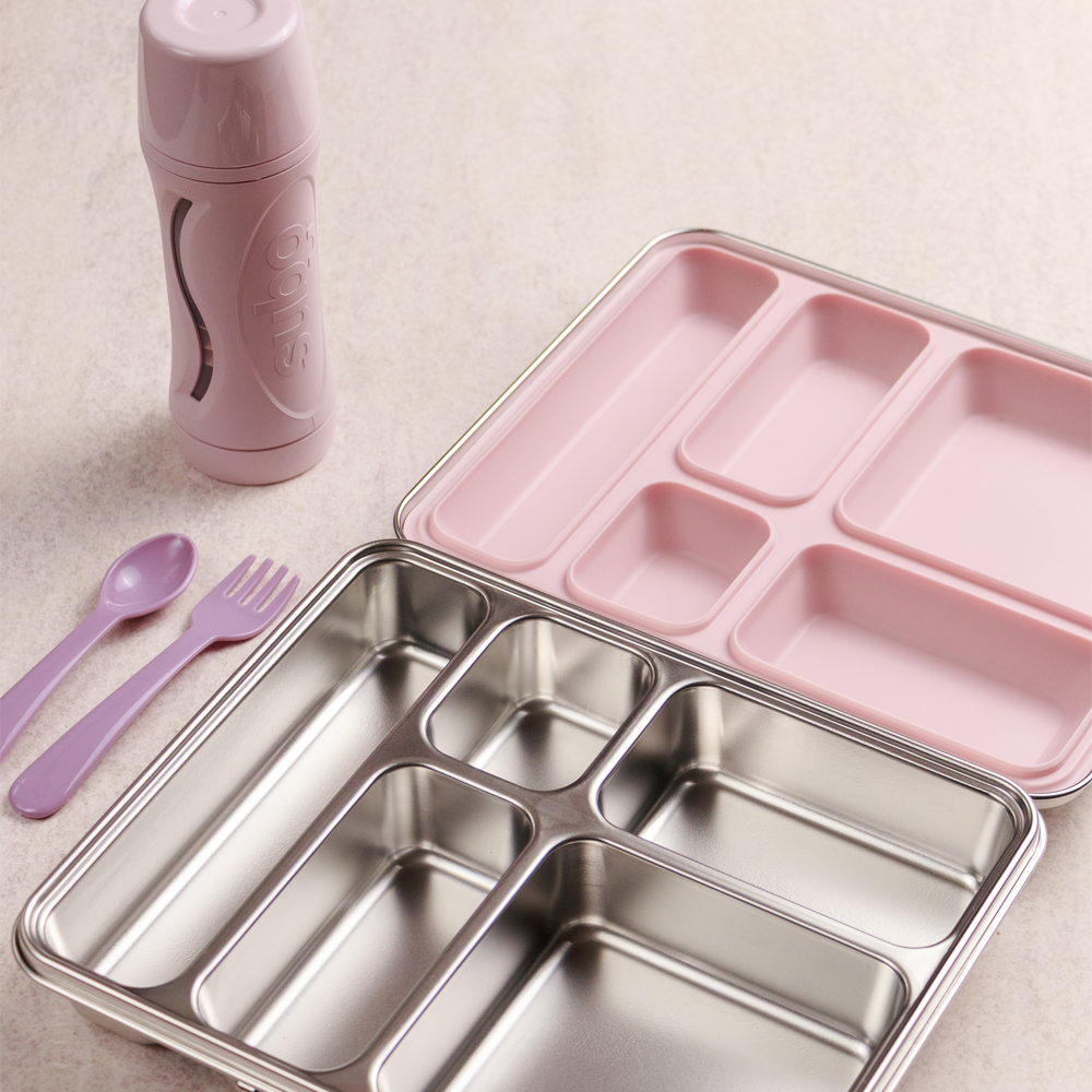 Pink bento box with compartments, pink thermos, spoon, and fork on a light background