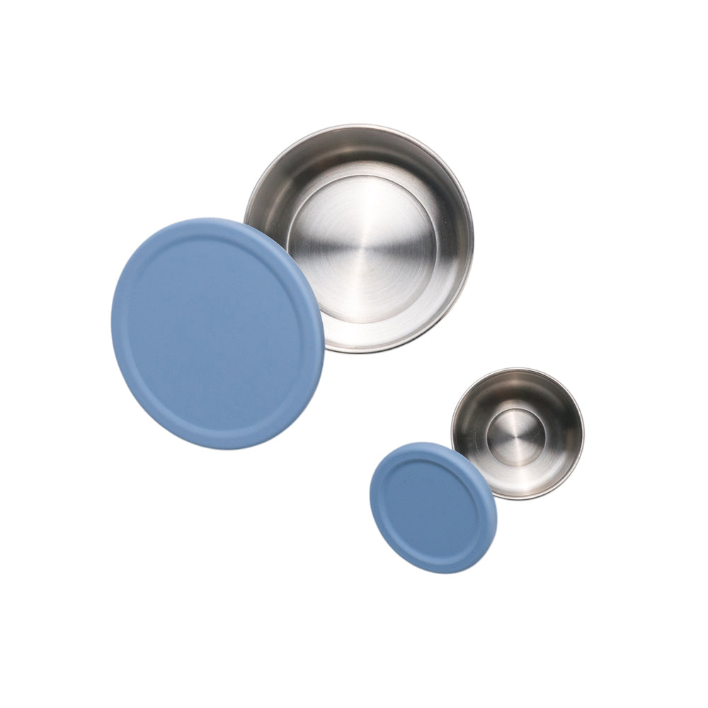 Set of stainless steel bowls with blue silicone lids on a white background
