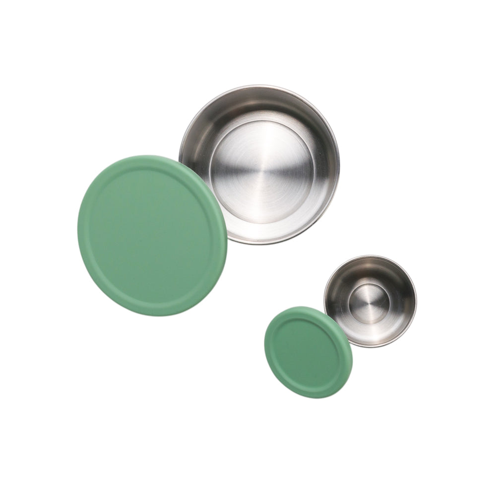 Two green lids and two silver metallic lids on a white background