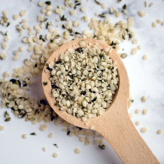 Wooden spoon filled with hemp seeds on a light background