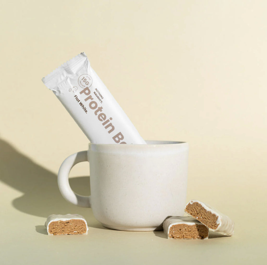 Protein bar with packaging and pieces on a beige background