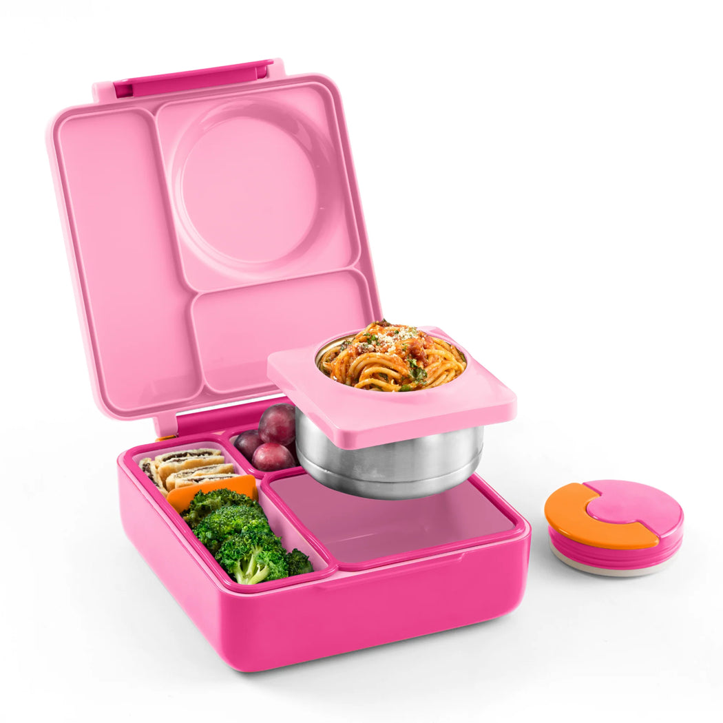 Pink bento box with compartments containing food on a white background